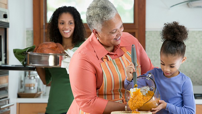 Three generations of Black women cooking in kitchen